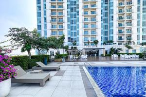 a swimming pool in front of a large building at Trillium Apartment - Cozy and Bright Downtown Surabaya by Le Ciel Hospitality in Surabaya