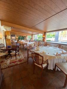 un comedor con mesas, sillas y ventanas en Bungalow BAMBOLERA en Torrelaguna