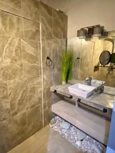 a bathroom with a sink and a stone wall at Villa Condesa Del Mar in Contadora