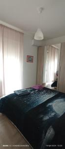 a bedroom with a large bed with a black comforter at LoVe House - Apartment on the beach in Pescara