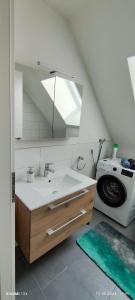ein Badezimmer mit einem Waschbecken und einer Waschmaschine in der Unterkunft Schicke Ferien Wohnung mit tollem Ausblick in Schwarzwald. in Villingen-Schwenningen