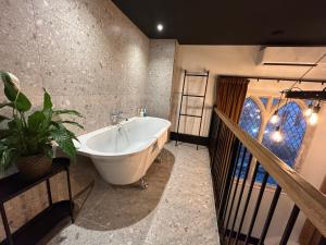 een badkamer met een bad en een potplant bij Crescent Place in Cheltenham