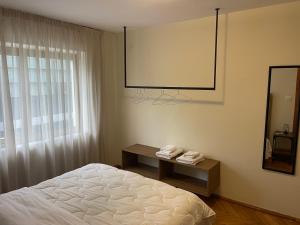 Schlafzimmer mit einem weißen Bett und einem Spiegel in der Unterkunft Cozy Apartment, in the center of Tirana in Tirana