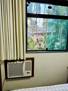 Habitación con ventana y aire acondicionado frente a una ventana con en Tombo Beach Hostel & Pousada, en Guarujá