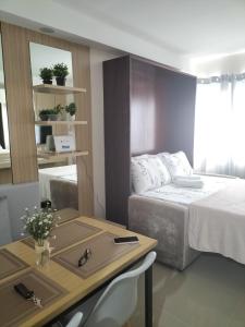 a bedroom with a bed and a table with a desk at Cozy1233 studio at The Persimmon in Cebu City