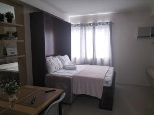 ein kleines Schlafzimmer mit einem Bett und einem Fenster in der Unterkunft Cozy1233 studio at The Persimmon in Cebu City