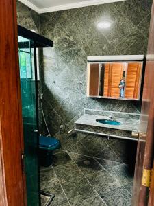 y baño con lavabo, aseo y espejo. en Tombo Beach Hostel & Pousada, en Guarujá
