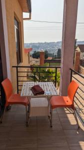 d'une table et de chaises sur un balcon avec vue. dans l'établissement Exquisite Apartments- 1Bedroom with nice view of Kigali City, Playground for kids, Close to Amusement Park, à Kigali