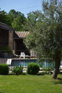 a swimming pool with a tree in a yard at ferme st pierre 2 suites avec repas, piscine, clim, cheminée ou baignoire spa in Chabeuil
