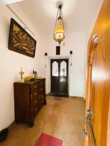 a room with a black door and a wooden dresser at Villa Mon Cheri in Pondicherry
