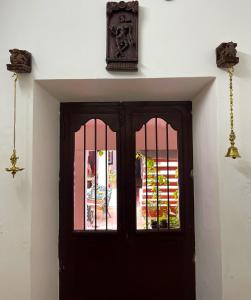 a door with a window and a clock above it at Villa Mon Cheri in Pondicherry
