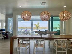 a dining room with a table and chairs and windows at 3891 Bayside in Fort Myers Beach