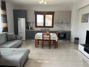 a living room with a table and a kitchen at Gästehaus Dimitra in Paralia Dionysiou +3 photos