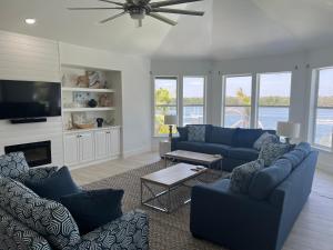 uma sala de estar com sofás azuis e uma televisão em 3891 Bayside em Fort Myers Beach