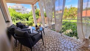 a screened in porch with chairs and a table at Suite by the beach in Cavtat