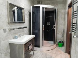 een badkamer met een douche en een witte wastafel bij 2 Bedrooms Apartment on 28 May Metro in Baku