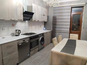 een keuken met een fornuis, een wastafel en een tafel bij 2 Bedrooms Apartment on 28 May Metro in Baku