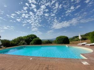 une piscine sur une terrasse en briques sous un ciel bleu dans l'établissement Il Borghetto, à Todi