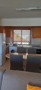 a kitchen with a table and chairs and a refrigerator at Apartamento Solar dos Pinheiros in Vilamoura