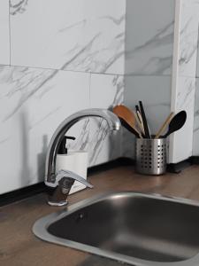 a kitchen sink with a faucet and some knives at AM Chinorros Square. in Fuengirola +42 photos
