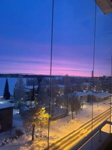 a view of a snowy city at night at Cozy lake view room by city center in Kuopio