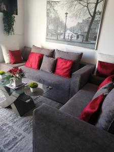 a living room with a gray couch and red pillows at Amazing Sea Place in Limassol