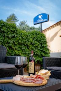 una botella de vino y un plato de carne y un vaso en L'antico gabbiano B&B, en San Casciano in Val di Pesa
