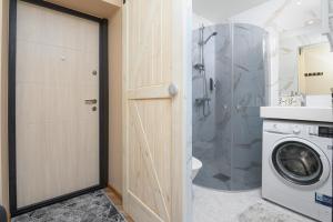 a bathroom with a washing machine and a washer at Ernakodu in Pärnu