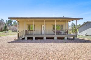 a small yellow house with a large porch at Deck and ATV Trail Access Quiet Cabin in Show Low in Show Low