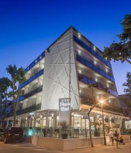 un gran edificio de cristal con gente delante de él en Piccolo Hotel, en Bellaria-Igea Marina