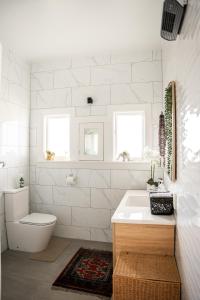 a white bathroom with a toilet and a sink at Charming 1920s Villa on Bealey Ave in Christchurch