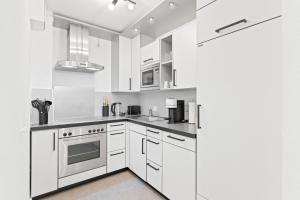 a white kitchen with white cabinets and appliances at Kingsize Bett, Naturidylle, Netflix, Großräumig in Pforzheim