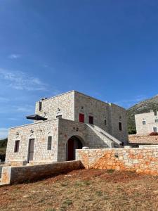 een groot bakstenen gebouw met een rode deur bij Sugar Stone House 2 in Pirgos Dhirou