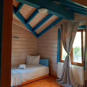a bedroom with a bed in a room with a window at WOODEN HOUSE in Preveza