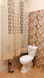 a bathroom with a toilet and a shower curtain at Exotic Hill View Stay in Karachi