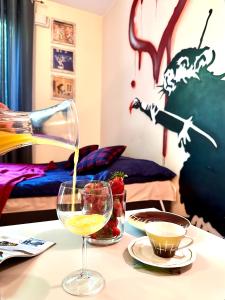 einen Tisch mit einem Glas Wein auf dem Tisch in der Unterkunft "Banksy" Art in Warschau