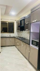 a large kitchen with brown cabinets and appliances at Exotic Hill View Stay in Karachi