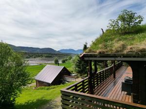 a building with a grassy roof with a wooden deck at Traditional Norwegian log cabin with sauna by the sea in Tornes