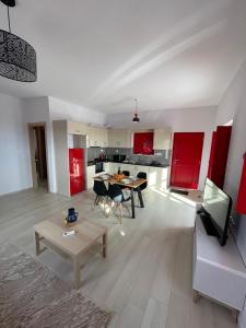 een woonkamer met een tafel en een keuken met rode kasten bij Sugar Stone House 2 in Pirgos Dhirou