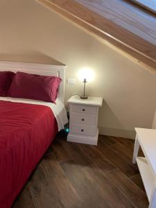 sypialnia z czerwonym łóżkiem i szafką nocną w obiekcie Albergo del Bramante w mieście Roccaverano