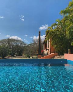 a swimming pool in front of a house at Hacienda San Francisco Tzacalha in Dzidzantún