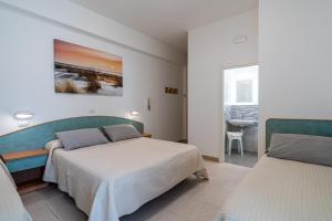 1 dormitorio con 2 camas, mesa y ventana en Piccolo Hotel, en Bellaria-Igea Marina