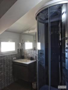 La salle de bains est pourvue d'un lavabo et d'une douche. dans l'établissement FAVARA Rooms, à Portopalo di Capo Passero