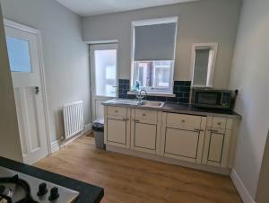 a kitchen with a sink and a microwave at Alexander Apartments High Heaton in Gosforth
