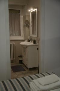 een witte badkamer met een wastafel en een spiegel bij Casa Mia Guesthouse in Rome