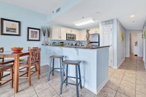 a kitchen with a bar and a table and chairs at Beach Club C-102 in Gulf Highlands