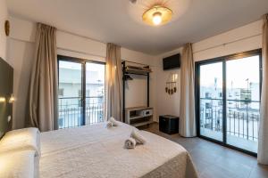Un dormitorio con una cama grande y un balcón. en Hostal Alicante, en San Antonio 37 fotos más