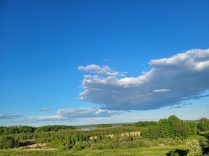 een blauwe lucht met wolken boven een groen veld bij Wyskok 1 - dom z widokiem in Srokowo