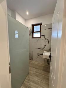 een badkamer met douche en wastafel bij Joen Apartment 2 in Sarandë +5 foto's