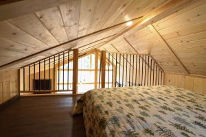 a bedroom with a bed in a room with windows at Chalets Lanaudière in Rawdon